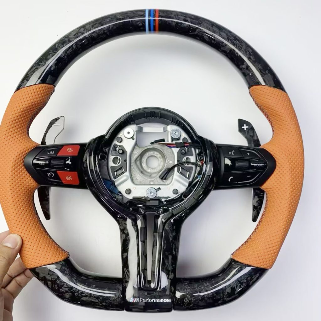 MW steering wheel with Hermès Orange Nappa leather, white-flake forged carbon, red M1/M2 buttons and carbon paddles