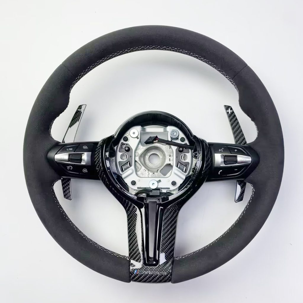 BMW steering wheel with black Alcantara, white stitching, gloss carbon trim and extended carbon paddles